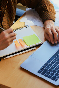 Planning tasks with notebook and laptop in shared workspace