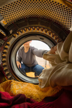Doing chores: woman closing door of washing machine/ dryer