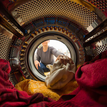 Doing chores: woman closing door of washing machine/ dryer