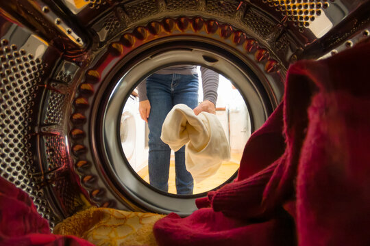 Doing chores: woman closing door of washing machine/ dryer