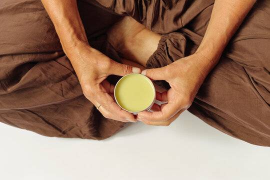 Female hands holding skincare balm cream product 