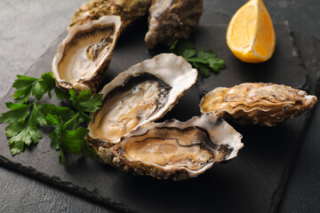 Board with delicious fresh oysters, parsley and lemon on black background, closeup © Pixel-Shot