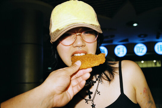 Girl eating a fried chicken cutlet