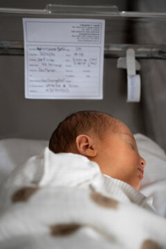 Newborn baby sleeping in hospital bassinet