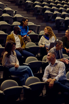 People talk in the auditorium