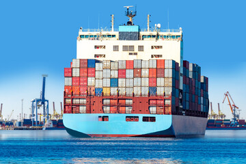 Maritime transport, container shipping. Large cargo ship loaded with stacked containers sails from...