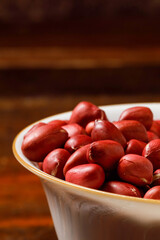 Obraz premium Red Skinned Peanuts in White Bowl