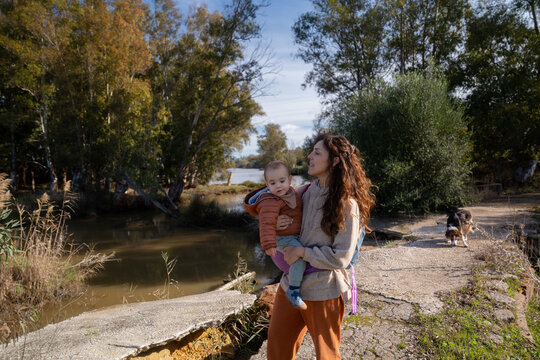 Mother carrying baby son walking outdoors