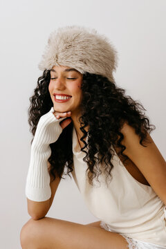 Happy woman wearing fur hat and fingerless gloves