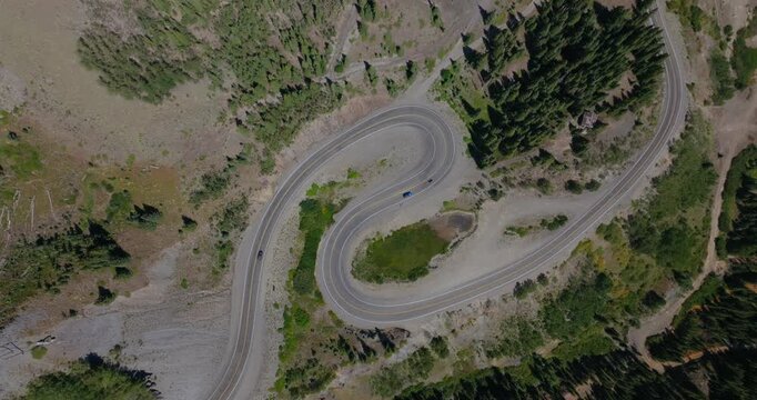 Dramatic aerial of steep mountain switchbacks cutting by rugged Colorado terrain, Million Dollay Highway Colorado USA