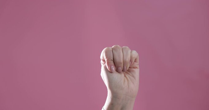 Signal for help. Senior woman gesturing on pink background, closeup