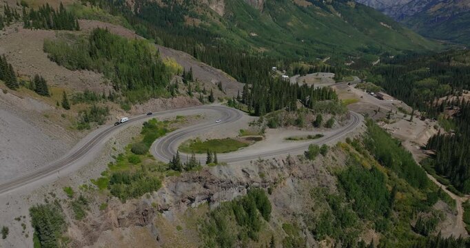 Aerial of winding mountain roadway of natural contours of alpine terrain, Million Dollay Highway Colorado USA