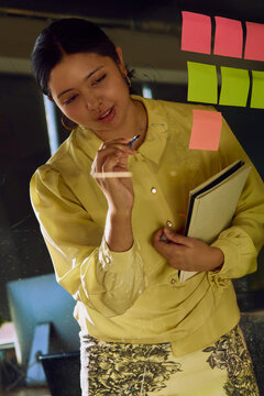 Business professional planning tasks with sticky notes