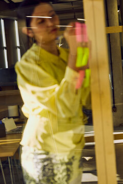 Business professional planning tasks using sticky notes