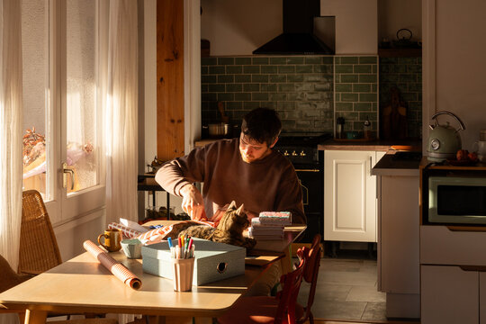 Man wrapping gifts at home