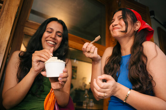 Friends Enjoy Ice Cream at a Local Shop on a Sunny Afternoon