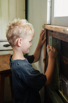 A boy drawing in the walls of a home