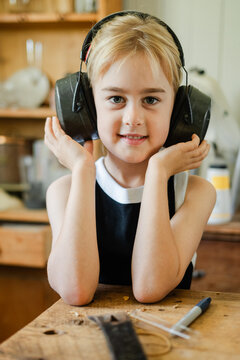 A young girl in sound blocking ear muffs