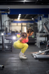 Fototapeta premium Woman doing barbell squats for leg training