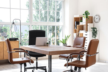 Interior of conference hall with table, shelf unit and plants