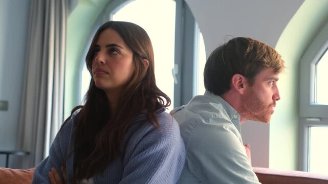 Beautiful lady is depressed, sitting on the couch talking to man, having a dispute with husband or girlfriend, looking desperate and hopeless, having unresolved problem or question
