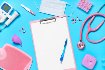 Blank clipboard with pills and medical supplies on blue background. World Health Day