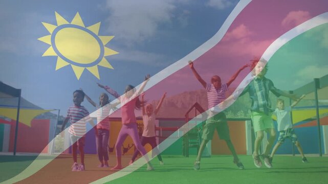 Seven children on teacher cue raising arms and jumping in unison for school, flag overlaying frame