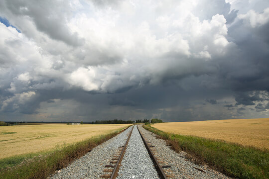 Train tracks leading into dramatic summer storm.
