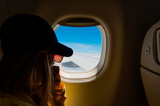 Mujer mirando por la ventana del un avion.