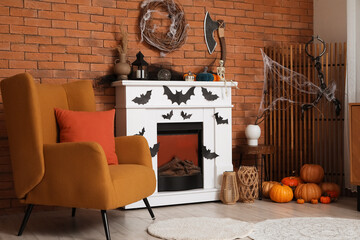 Fototapeta premium Interior of festive living room with Halloween decorations, armchair and fireplace
