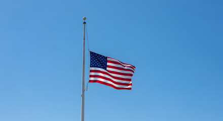 Obraz premium American flag flying at half-staff on a white flagpole against a