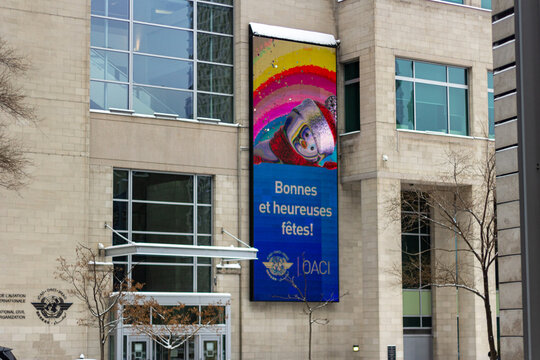 MONTREAL, CANADA, 24 December 2025 : Holiday banner on office building exterior, international civil aviation organization, festive greeting, winter city scene, architecture and signage