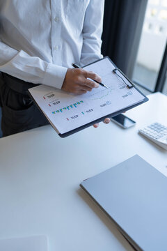Businessman standing chekking documents with pen