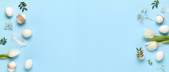 Frame made of Easter eggs with flowers, leaves and feathers on blue background