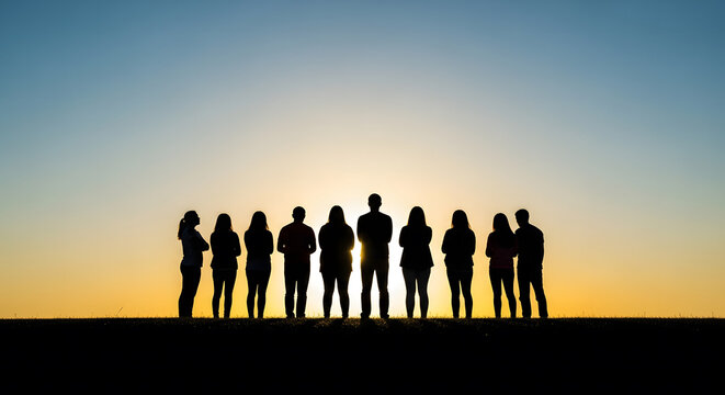 Silhouette of a group of people standing in a row against a brig