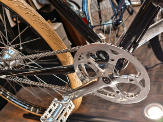 Obraz premium Bicycle close-up showcasing intricate details and craftsmanship in a modern shop during daylight hours