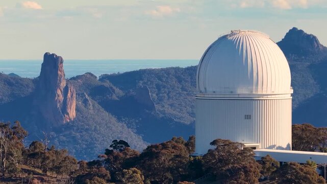 White Astronomical Observatory Dome in Rugged Mountain Landscape Aerial View