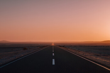 Long Desert Highway Leading to Orange Pink Sunset Horizon with Expansive Sky Visionary Journey Concept