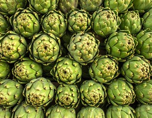 Obraz premium Close-up of numerous green artichokes, tightly packed and displayed. The spiky vegetables create a visually appealing, textured pattern