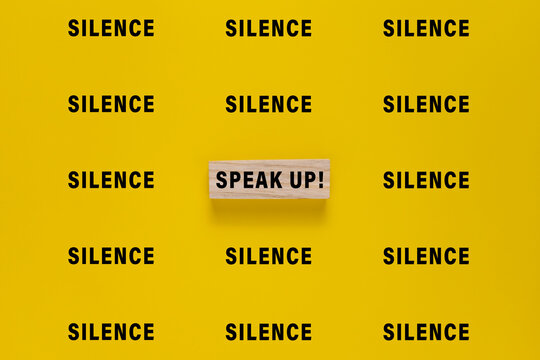silence words and single speak up word. isolated on yellow background. concept of advocacy