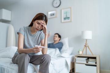 Obraz premium Asian young woman feel shock after look at positive pregnancy test. 