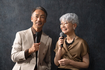 マイクを持って歌を歌うシニア男女　ライフスタイルイメージ