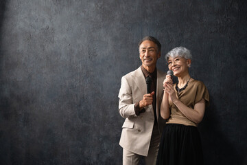 マイクを持って歌を歌うシニア男女　ライフスタイルイメージ