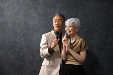 マイクを持って歌を歌うシニア男女　ライフスタイルイメージ