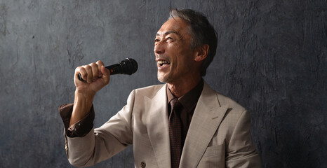 マイクを持って熱唱するシニア男性　ライフスタイルイメージ