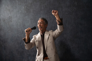 マイクを持って熱唱するシニア男性　ライフスタイルイメージ