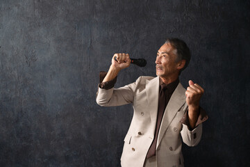 マイクを持って熱唱するシニア男性　ライフスタイルイメージ