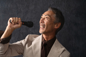 マイクを持って熱唱するシニア男性　ライフスタイルイメージ
