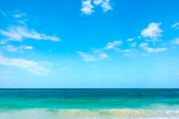 Obraz premium Tropical Nature clear sky and summer sea water under a clear blue sky with beautiful clouds and bright sunlight. Perfect for summer vacation and travel background