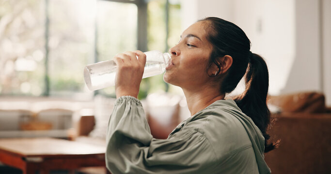 Woman, relax or drinking water in living room with bottle, wellness or natural detox for gut health. Thirsty, mature person and liquid beverage in home with hydration, nutrients or digestion benefits
